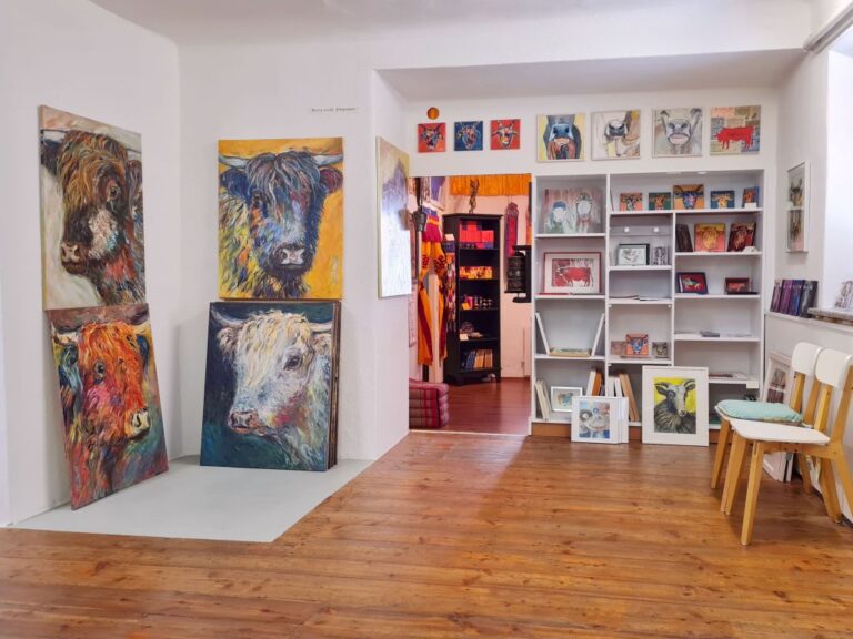 Blick in die Galerieräume der KUHNST GALERIE GMÜND mit farbigen, gemalten Kuhportraits von Theresa Beitl